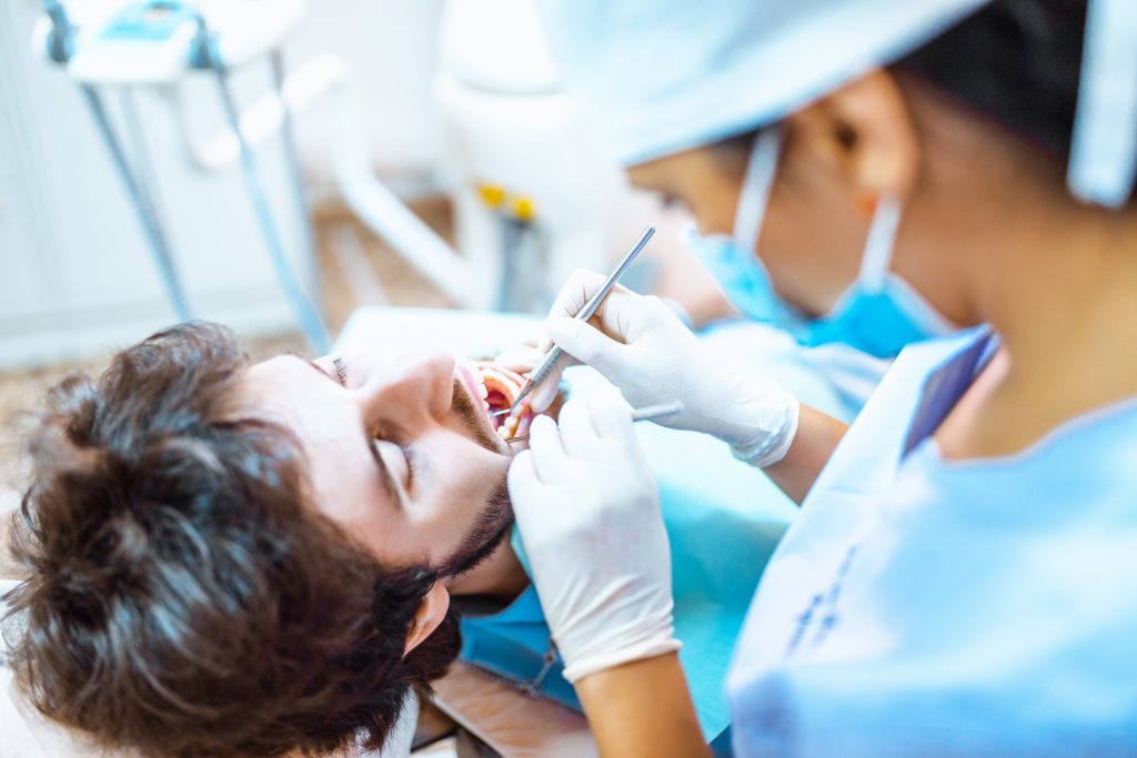 dentiste ptratiquand des soins dentaires sur un patient
