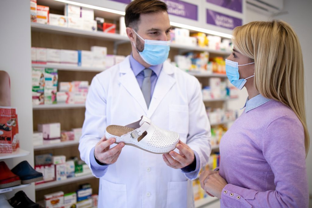 cliente d'une pharmacie qui achète une chaussure orthopédique