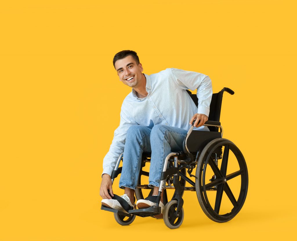 jeune homme souriant en fauteuil roulant