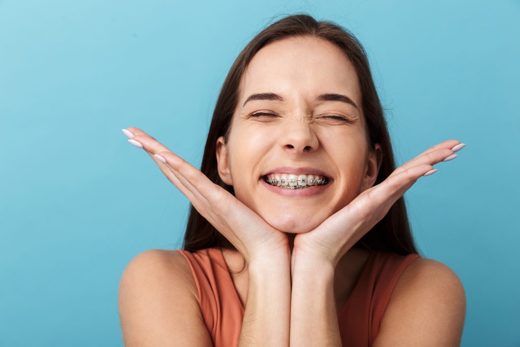 une femme sourit pour montrer son appareil dentaire