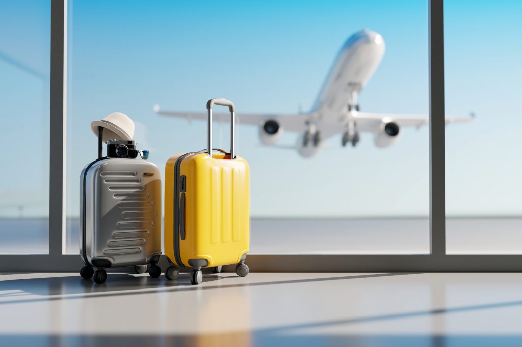 valises dans un aéroport avec un avion qui décolle