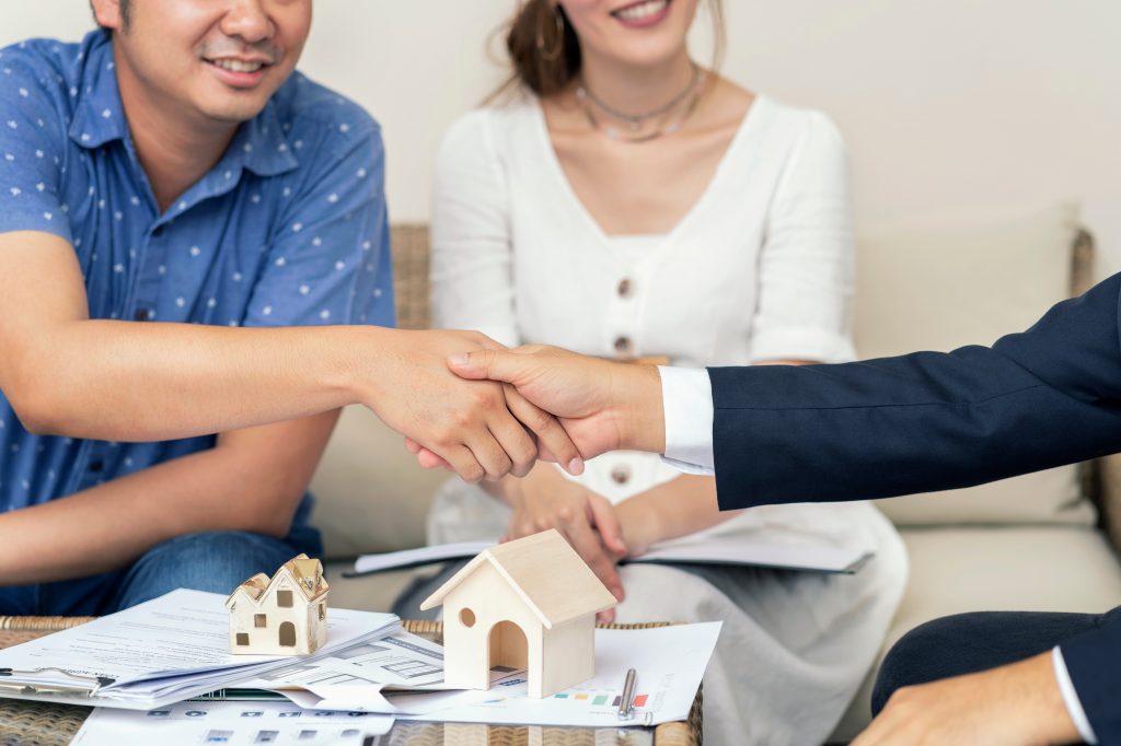 couple chez l'assureur signe un contrat d'assurance emprunteur