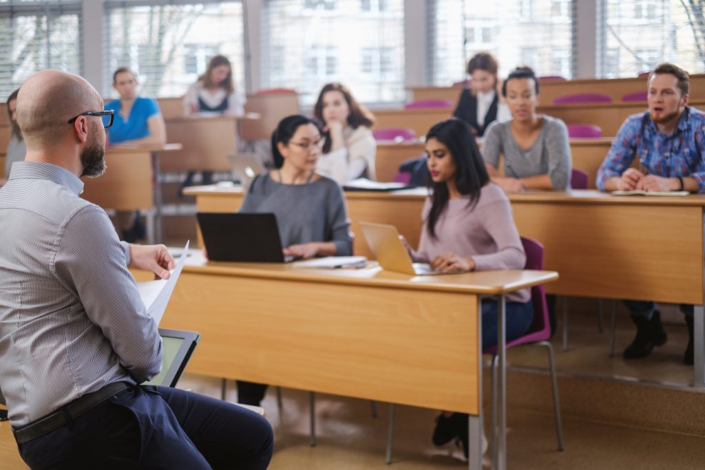 étudiants en salle de cours avec table en bois clair